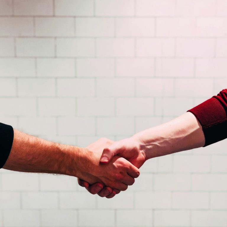 Handshake samenwerking Twee handen schudden elkaar in een zakelijke overeenkomst.