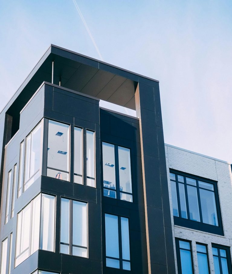 Appartement Moderne appartementencomplex met grote ramen en een minimalistisch ontwerp.